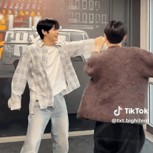two men are dancing in front of a wall that has a van on it
