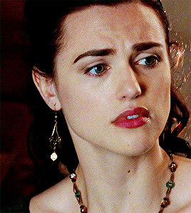 a close up of a woman 's face with a necklace around her neck