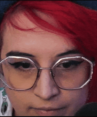 a woman with red hair is wearing glasses