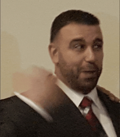 a man in a suit and tie is making a face .