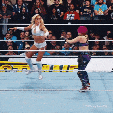 two women wrestling in front of a crowd with one wearing a packers shirt