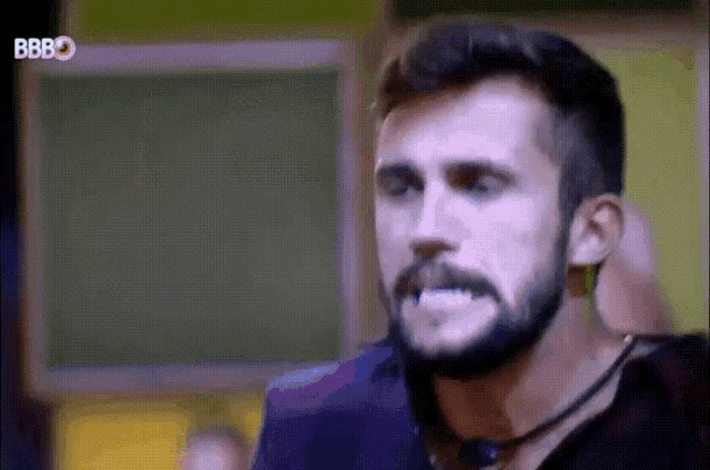 a man with a beard and mustache is making a funny face with his mouth open .