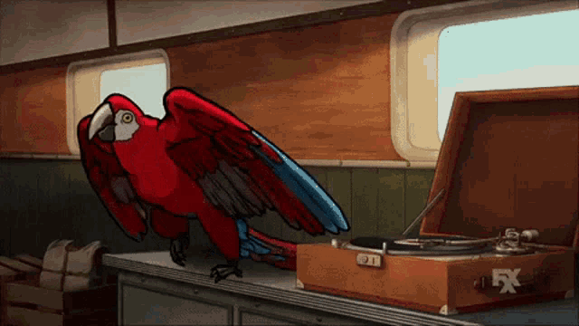 a red parrot is standing next to a record player that says fx on it