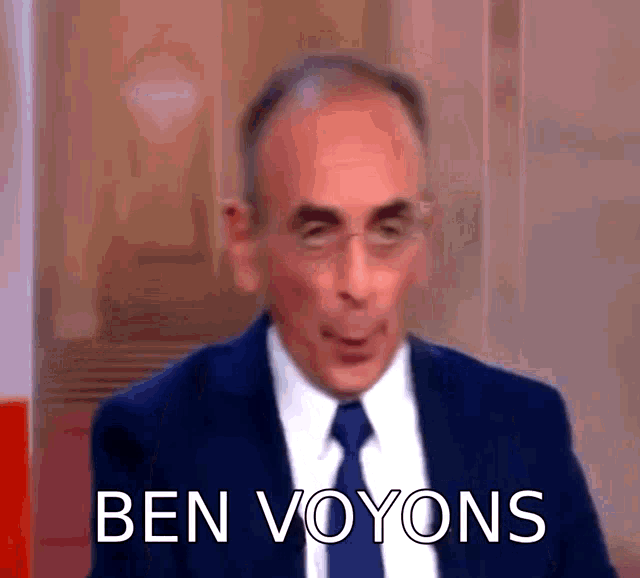 a man in a suit and tie is making a funny face while talking on a television show .