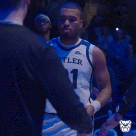 a man wearing a butler jersey number 21 stands in front of a crowd