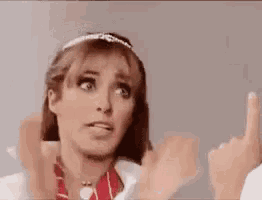 a woman is giving a thumbs up sign while wearing a headband .
