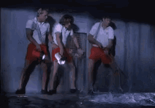 a group of people are cleaning a pool with a flashlight and a broom .