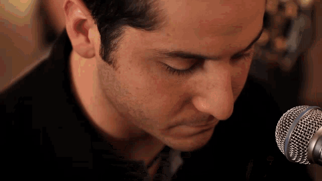 a close up of a man 's face with a microphone in front of him