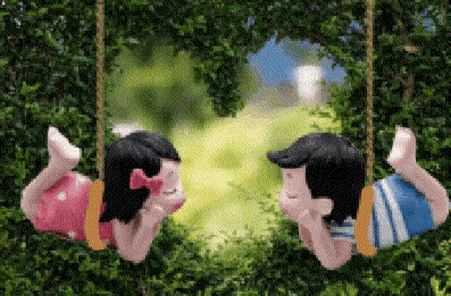 a boy and a girl are laying on a swing looking at each other