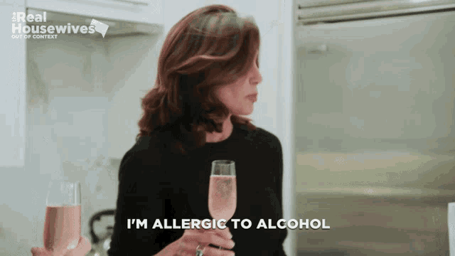 a woman is holding a glass of wine and says i 'm allergic to alcohol