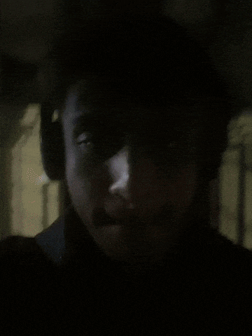 a man wearing headphones looks at the camera