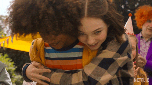 a girl hugging a boy with a netflix logo in the background
