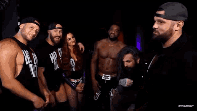 a group of wrestlers are posing for a picture and one of them is wearing a black tank top that says hogwarts