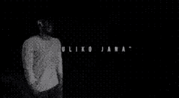a black and white photo of a man in a white shirt dancing in a dark room .