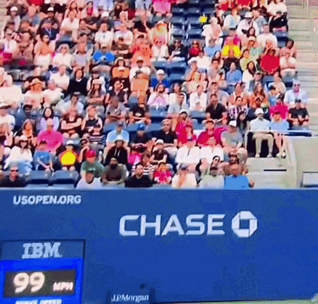 a crowd of people sitting in a stadium with a chase logo on the bleachers