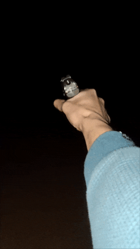 a hand holding a light bulb in the dark