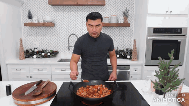 a man stirs food in a pan in a kitchen with the words made in animatica below him