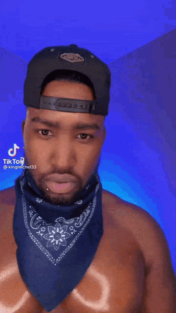 a shirtless man wearing a hat and a bandana has a tiktok account named kingmichael