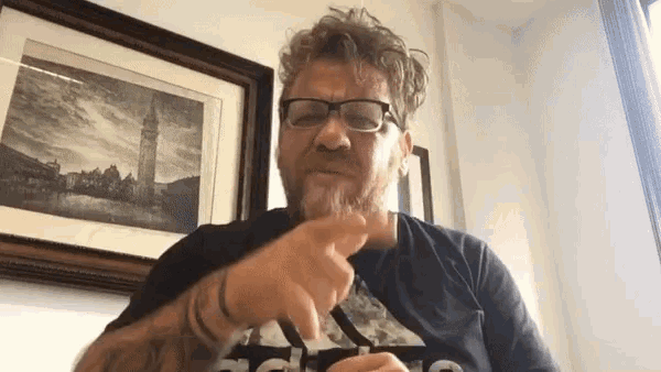 a man with glasses and a beard is pointing at something