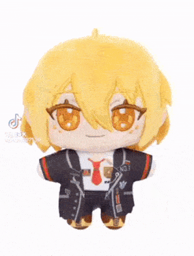 a stuffed toy of a boy with yellow hair and orange eyes is sitting on a table .