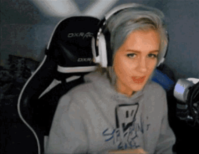 a woman with blue hair is wearing headphones and a sweatshirt that says ' sydney girl ' on it