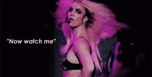 britney spears is wearing a black bra and dancing on a stage .