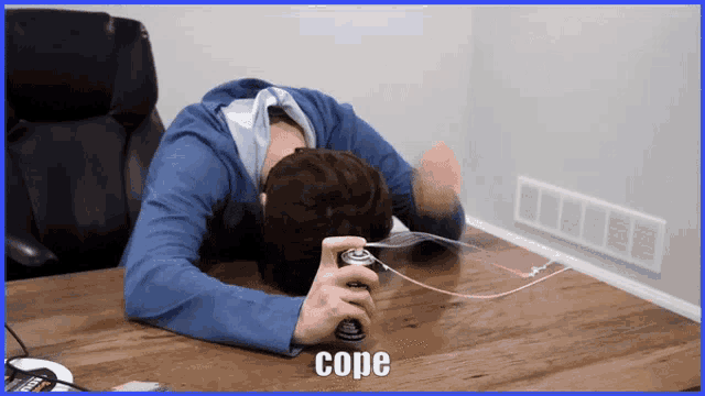 a man laying on a table with a can of cope in front of his face