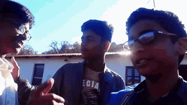 a boy wearing a shirt that says ecia is talking to another boy