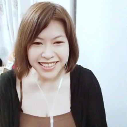 a woman wearing headphones and a black cardigan is smiling for the camera .