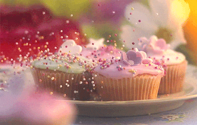 three cupcakes with pink frosting and sprinkles on them