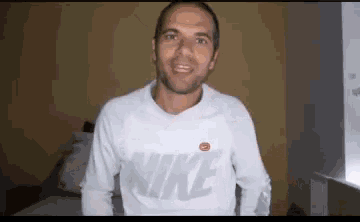 a man wearing a white nike shirt is talking