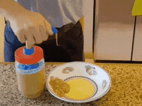 a person is pouring sauce into a bowl on a counter top