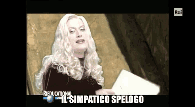 a tv screen shows a woman holding a piece of paper and the words " il simpatico spelogo " at the bottom