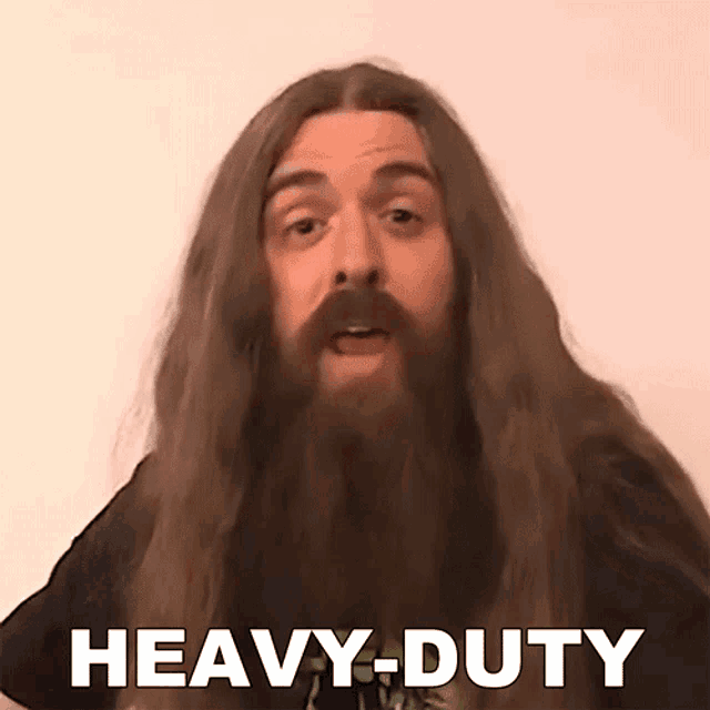 a man with long hair and a beard is saying heavy duty