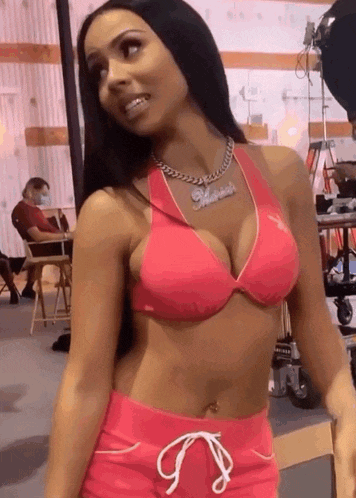 a woman wearing a pink bikini top and shorts has a necklace with the name marilyn on it