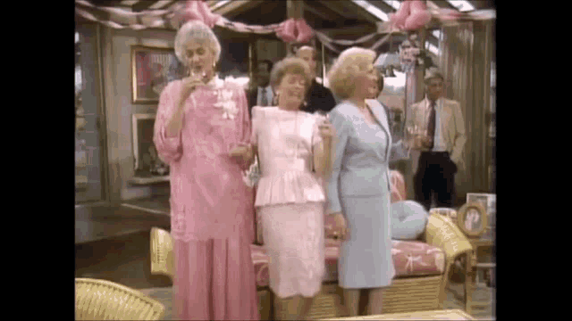 three women are standing next to each other in a living room holding glasses of champagne .