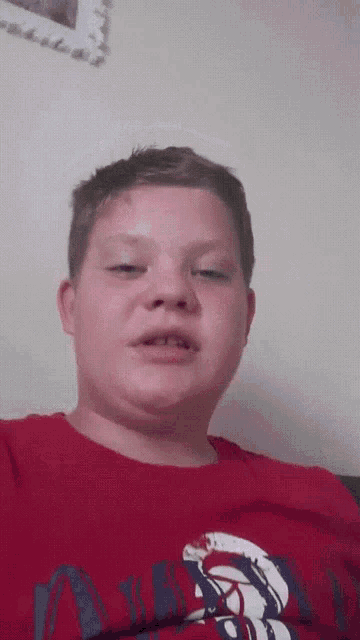 a young boy wearing a red shirt that says ' abercrombie & fitch ' on it