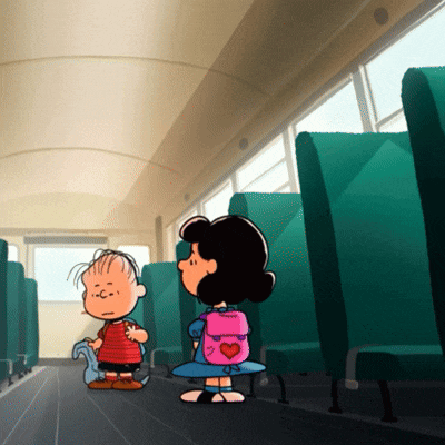 a girl with a pink backpack with a heart on it stands next to a boy on a bus