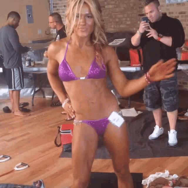 a woman in a purple bikini has a tag on her waist that says ' nm '