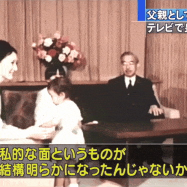 a man and a woman sit on a couch with chinese writing on the screen