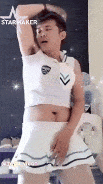 a man is wearing a skirt and a crop top that says starmaker on the top