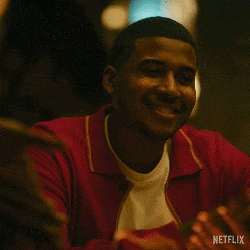 a man wearing a red sweater is smiling in a netflix advertisement