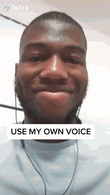 a man wearing headphones and a blue shirt with the words use my own voice below him
