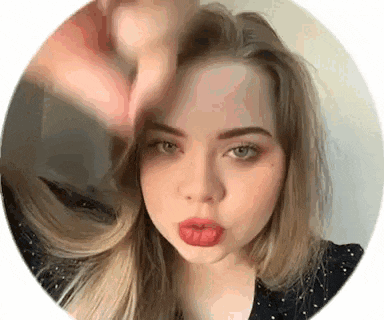 a close up of a woman 's face in a circle with a hand on her forehead .