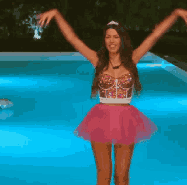 a woman in a pink dress is dancing in a pool with the words @tvresidence above her