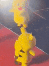 a couple of yellow stuffed animals are standing on top of each other on a red carpet .