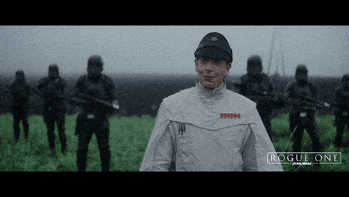 a man in a white uniform stands in front of a group of stormtroopers with the words rogue one star wars on the bottom