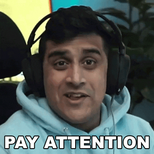 a man wearing headphones says pay attention in front of his face