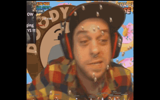 a man wearing headphones and a plaid shirt is playing a video game