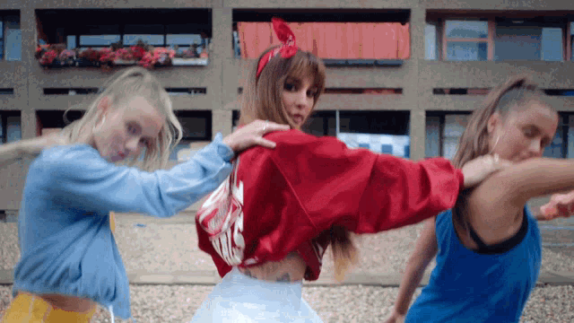 a woman in a red jacket is surrounded by other women